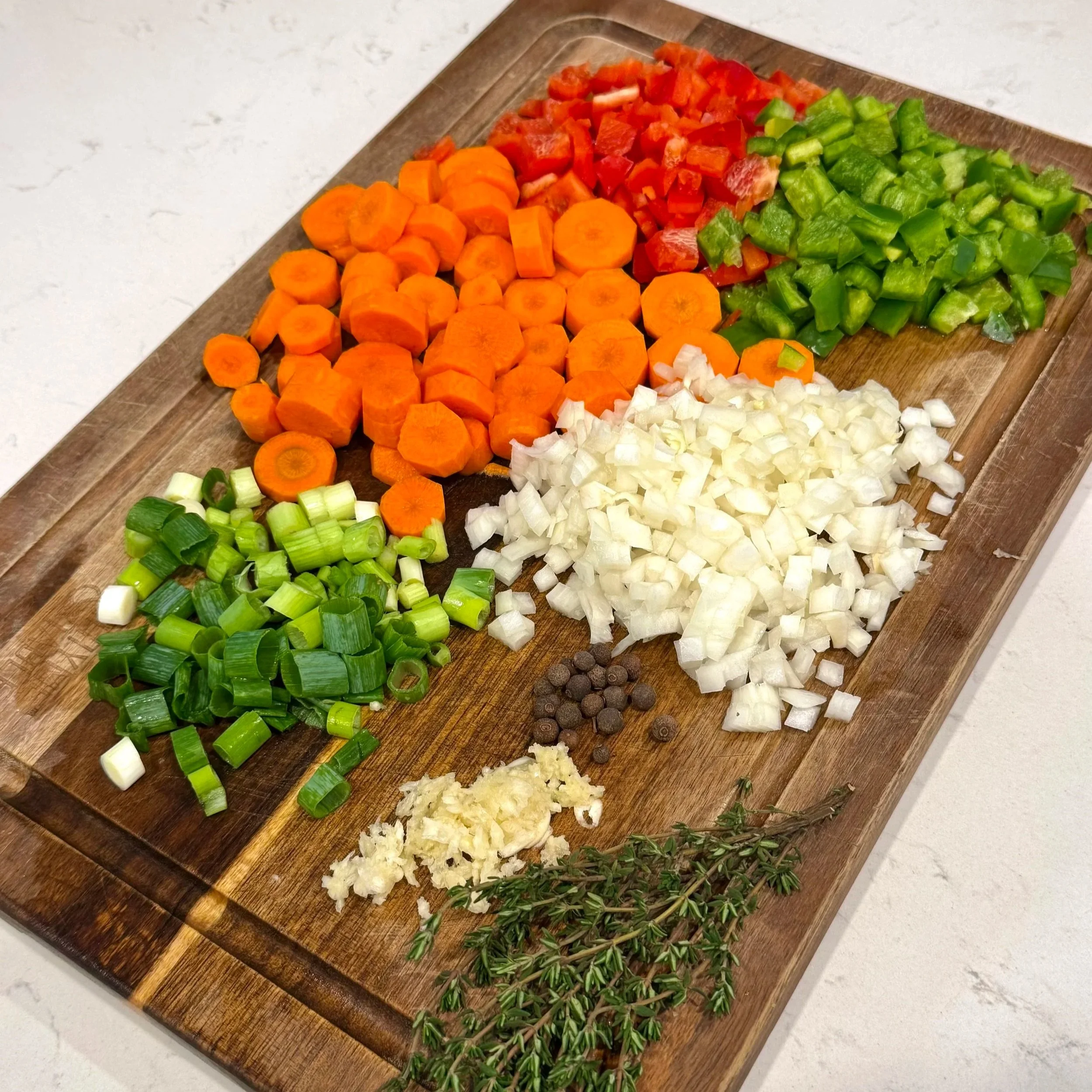 Fresh aromatics like carrots, bell peppers, onion, and thyme are the base of authentic Jamaican oxtail flavor.