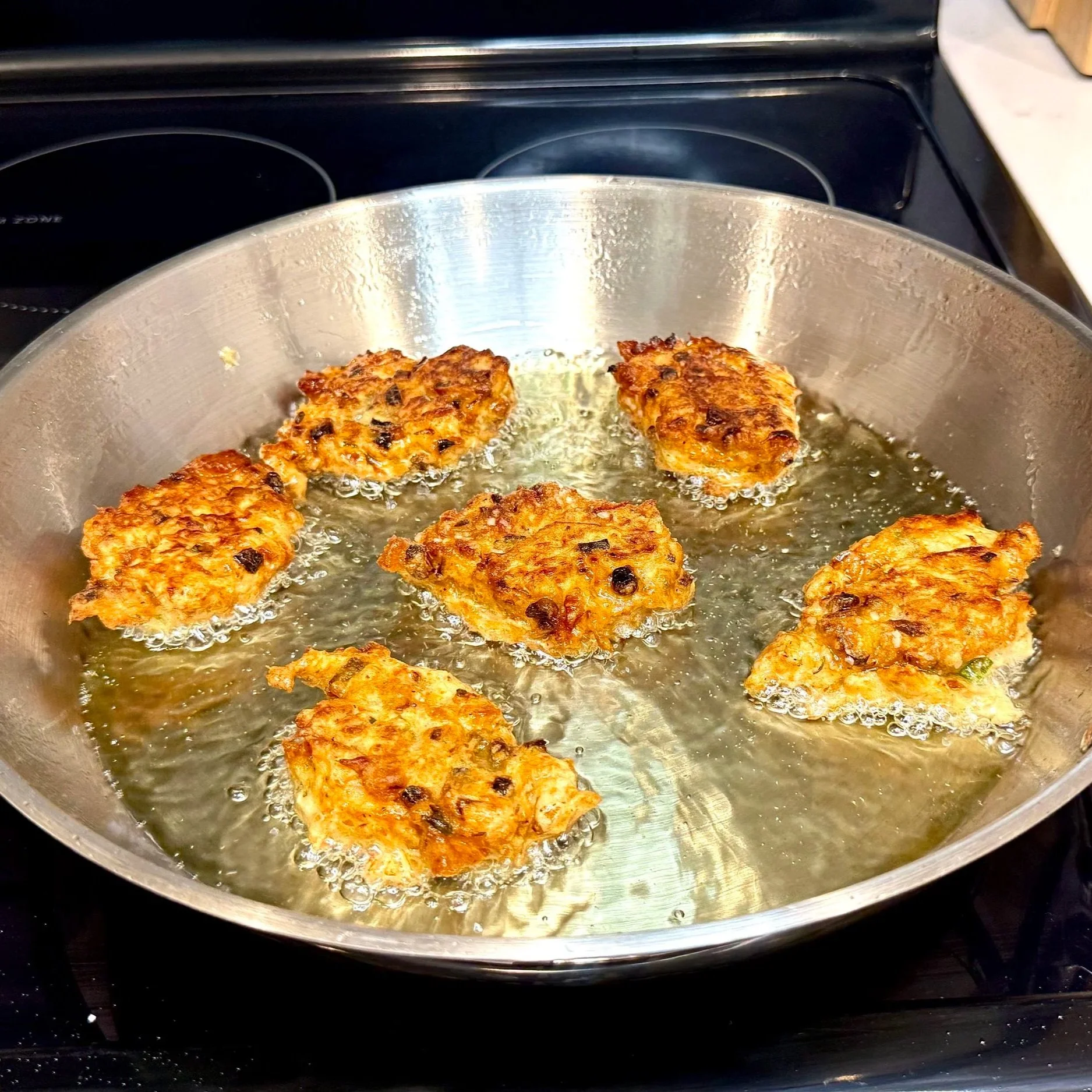 Fritters flipped to cook evenly on both sides for perfect crisp texture.