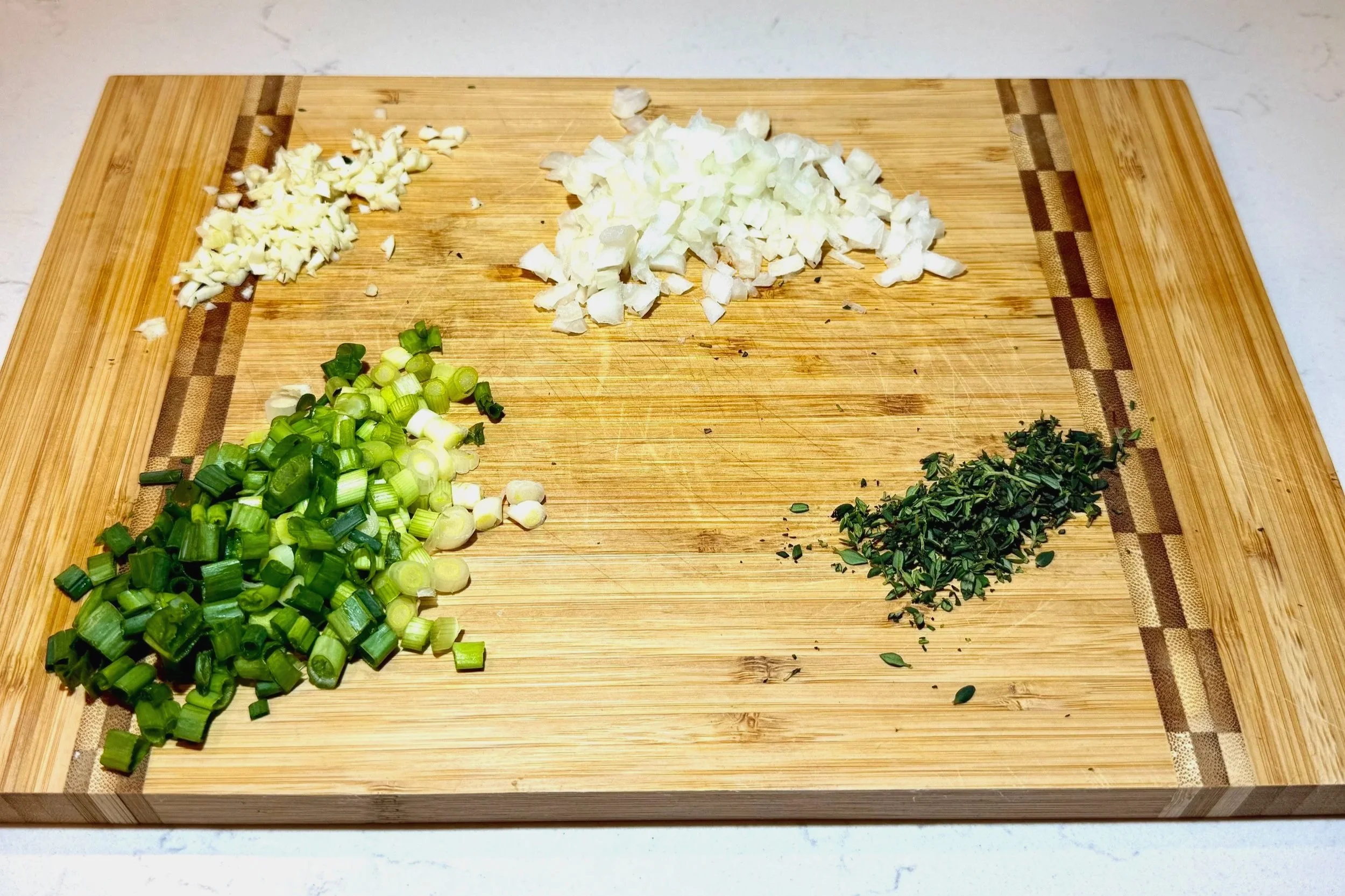 Fresh ingredients prepped for authentic Jamaican saltfish fritters (stamp and go), including herbs, aromatics, and salted cod.