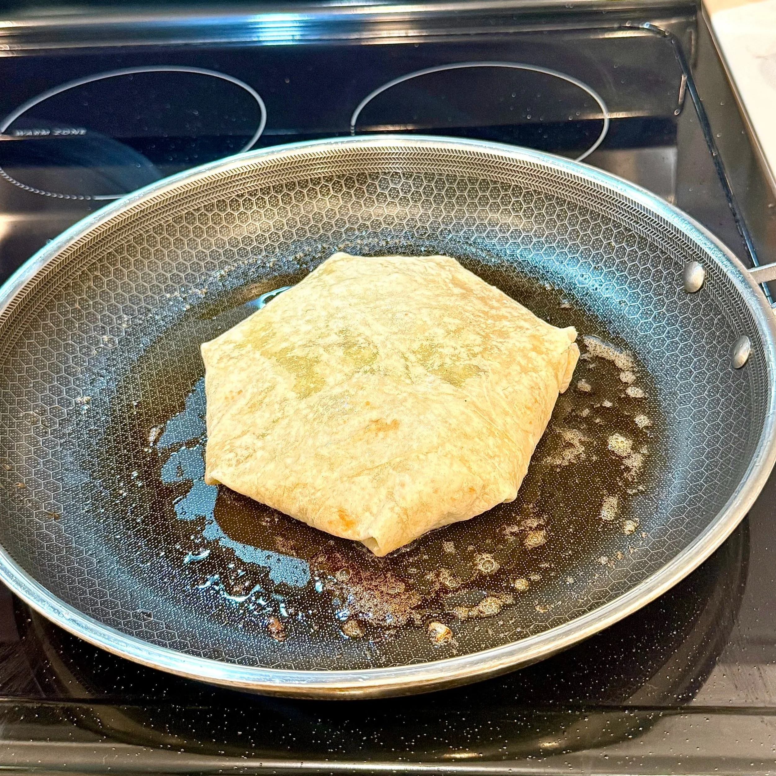  Crisping the wrap in a skillet seam side down first to  give it that perfect golden crunch.  