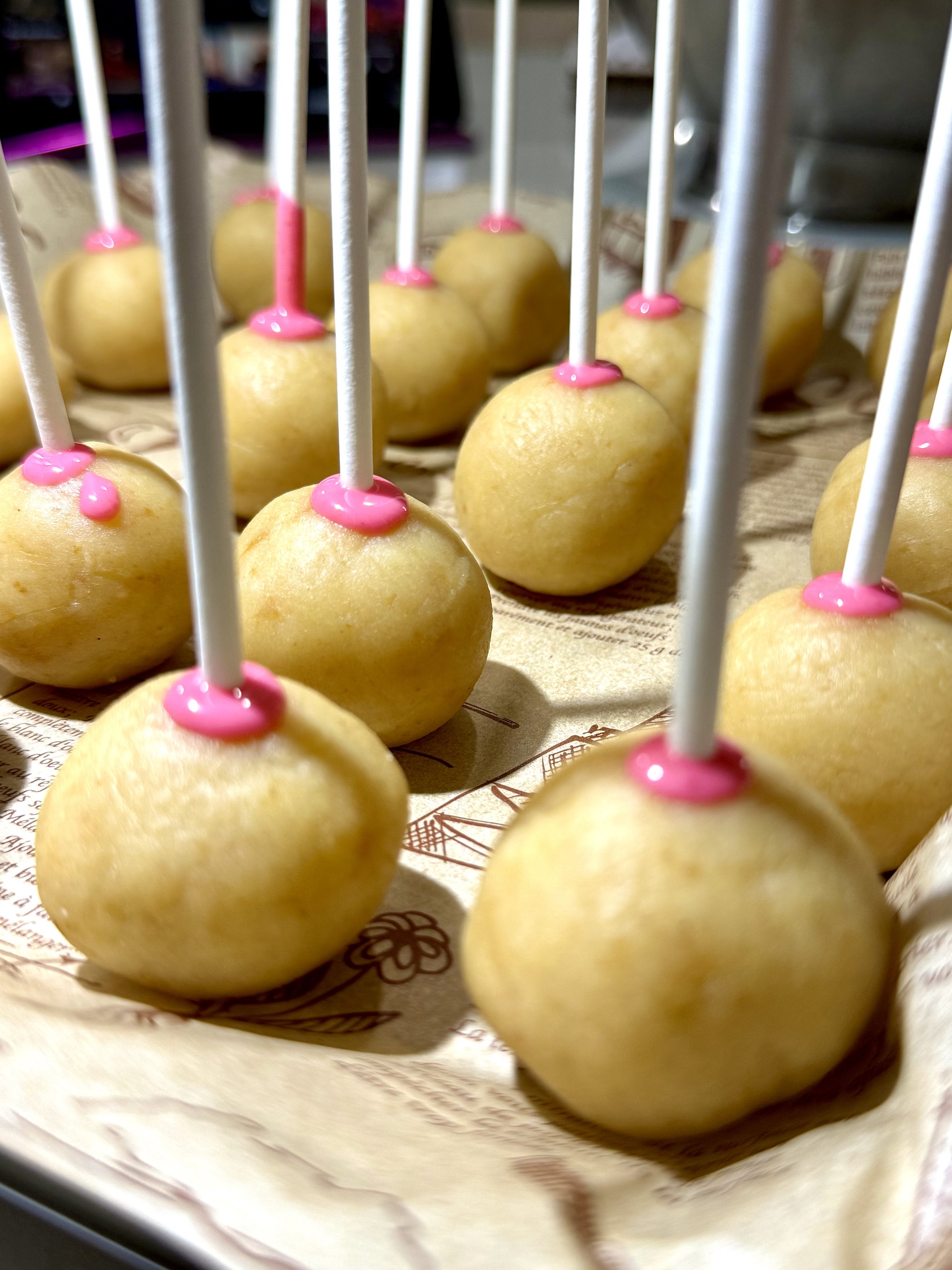 Dipping the cake pops into smooth pink candy coating — the secret to that glossy Starbucks finish.