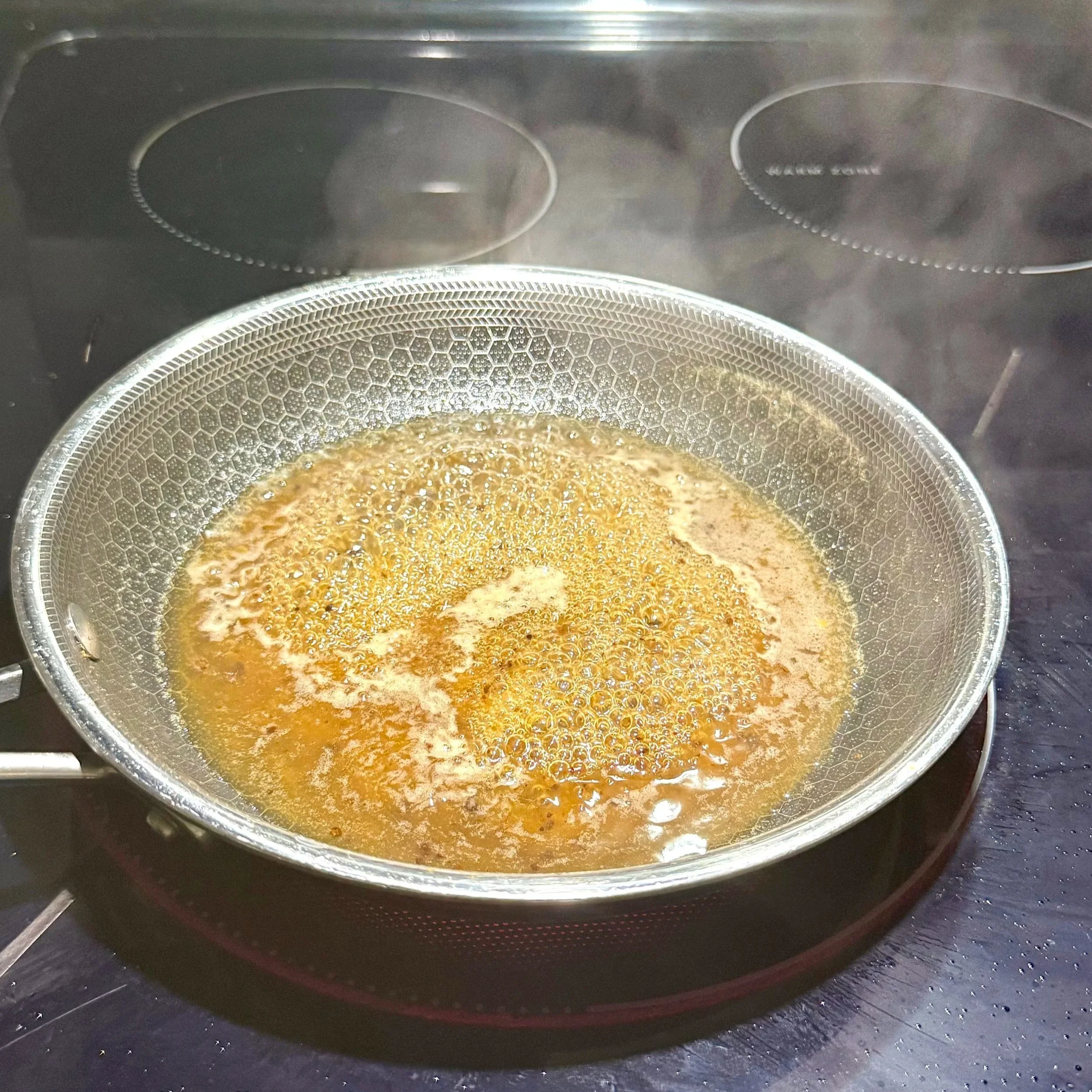  Combining pineapple juice, tamarind, vinegar, and honey to start the gastrique. 
