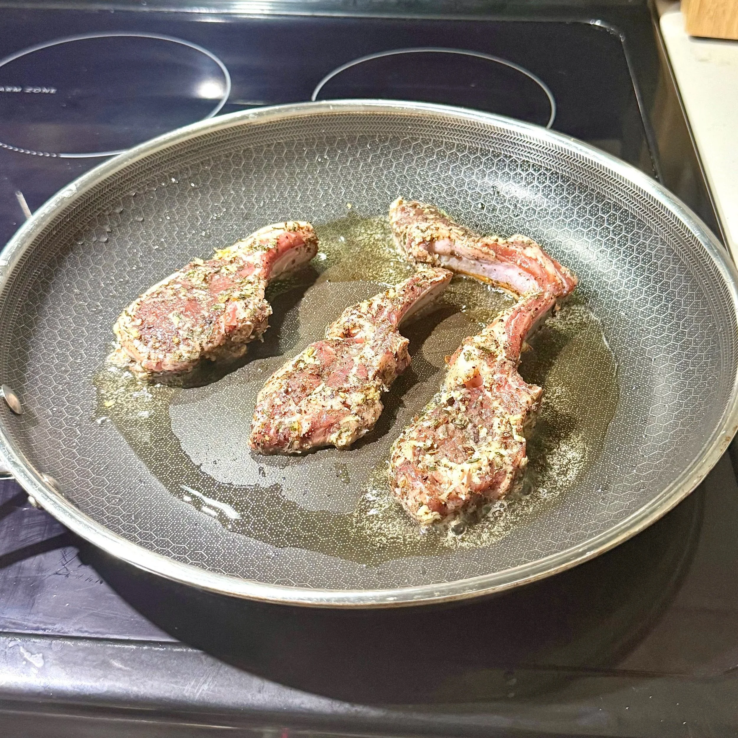  Searing the lamb chops to build a deep, caramelized crust. 